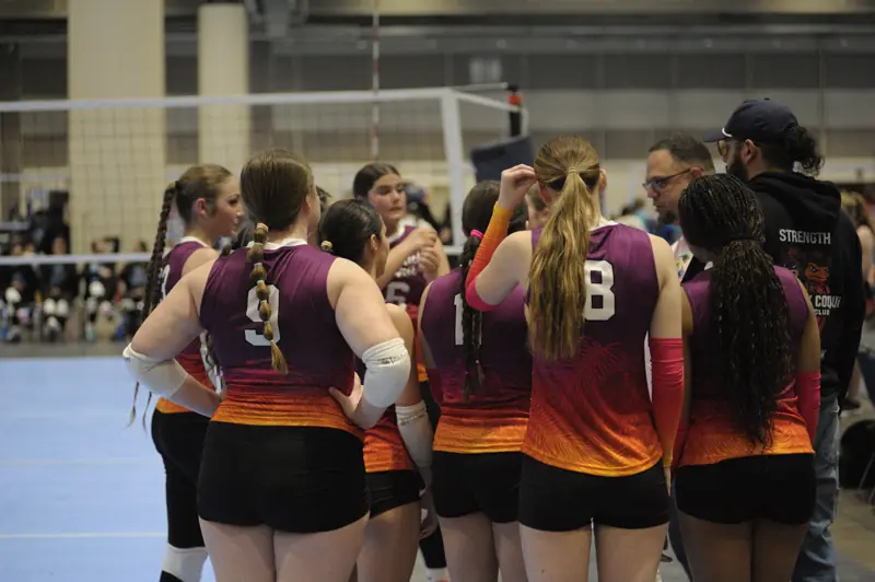 Players huddle with their coach between sets